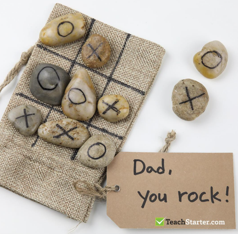 Tic-Tac-Toe A burlap bag has rocks on top of it with Xs and Os drawn on them. The tag says,