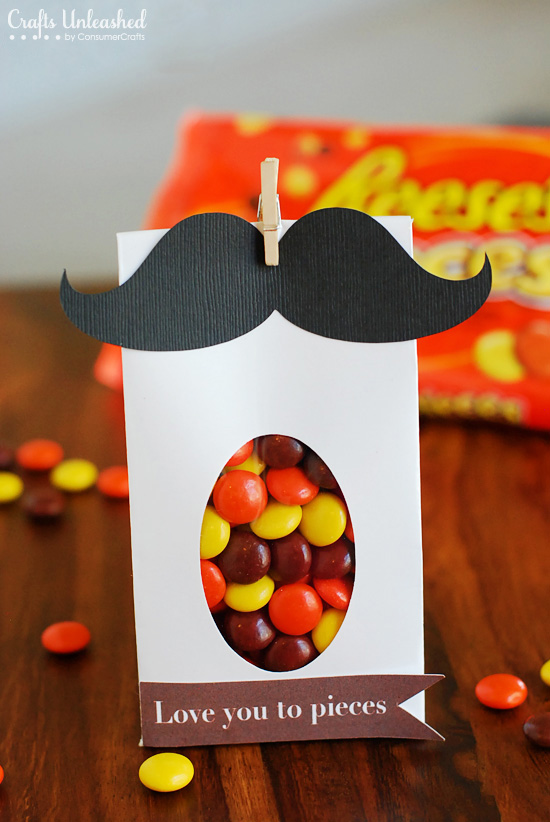 Moustache Bag A white bag is filled with candy and has a black moustache on the top.
