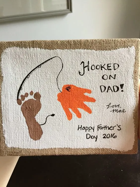 hooked-on-dad A canvas painted with a child's footprint and handprint