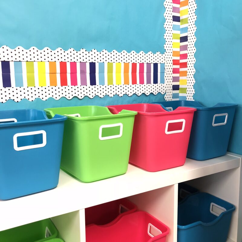 Shelf of brightly colored classroom storage bins.