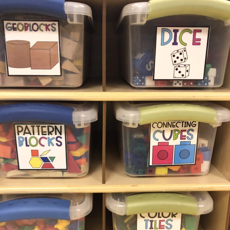 Classroom storage bins labeled with words and pictures.