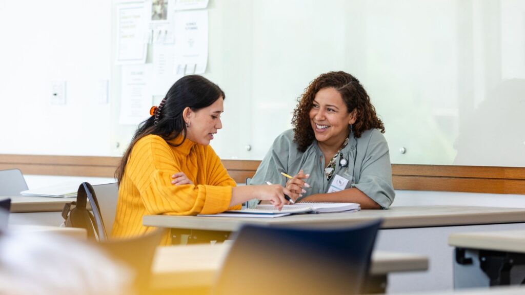 Teachers meeting in classroom discussing strategies for coteaching