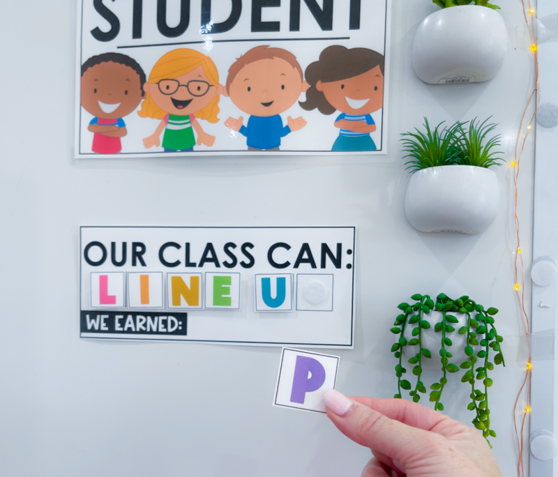 Line-up classroom management game on the wall with a teacher's hand holding the letter P